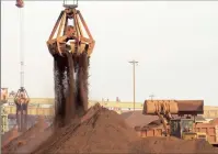  ??  ?? Cranes unload imported iron ore from a ship at a port in Rizhao, Shandong province, China. Iron ore’s price has plunged below $40 a ton.