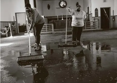  ?? Photos by Jon Shapley / Staff photograph­er ?? Senior pastor Enid Henderson, left, and lay leader Angela Jones mop water from a burst pipe at Ebenezer United Methodist Church.