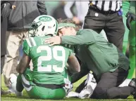  ?? Steven Ryan / Getty Images ?? The Jets’ Bilal Powell is tended to by a trainer during the second quarter against the Vikings on Sunday.