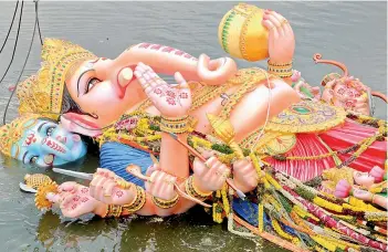  ?? DEEPAK DESHPANDE ?? The 57-foot tall Khairtabad Lord Ganesha sinks into the water after its immersion in Tank Bund. —