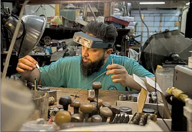  ?? NWA Democrat-Gazette/J.T. WAMPLER ?? Woody Maringer hand engraves dies for coin stamping at the Shire Post Mint in Springdale. The company makes collectibl­e coins based on several fantasy novels.