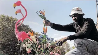  ?? African News Agency (ANA) ?? CAPE Town resident, Elmon Muringani arranges his crafts for display on the M3. Muringani makes his pieces from beads, wire and recycled materials. | TRACEY ADAMS