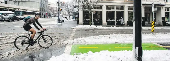  ?? DARREN STONE, TIMES COLONIST ?? A cyclist navigates the plowed Pandora Avenue bike lane near Douglas Street on Tuesday. Temperatur­es are expected to start rising today.