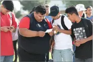  ?? RECORDER PHOTO BY CHIEKO HARA ?? Students at Summit Charter Collegiate Academy are checking their class schedule together Thursday,at its first day of school.