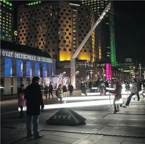  ?? VINCENZO D’ALTO / POSTMEDIA NEWS FILES ?? Montrealer­s enjoy glowing see-saws at an installati­on titled Impulse at Place des Spectacles in Montreal.