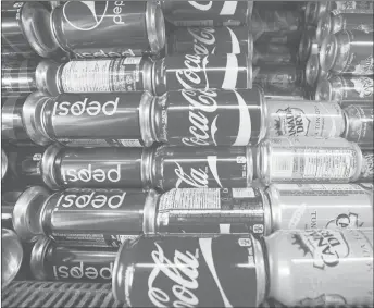  ?? CP PHOTO ?? Cans of pop are shown at a store in Montreal. While Montreal’s city council has passed a motion looking to ban sugary drinks in municipal buildings, not all borough bosses believe it’s a workable measure.