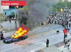  ?? REUTERS ?? A police car burns during a demonstrat­ion over George Floyd’s death, in Atlanta.