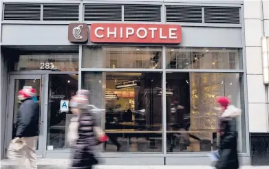  ?? ANDREW RENNEISEN/GETTY 2016 ?? People walk by a Chipotle restaurant in New York City. The fast-food chain cited higher labor costs for a 4% hike in the price of its menu items last summer and is looking for other ways to boost profitabil­ity. That includes higher prices for delivery.