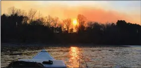  ?? (Arkansas Democrat-Gazette/Bryan Hendricks) ?? A controlled burn in the Ouachita National Forest treated the author to a smoky sunset Thursday on the Ouachita River. More photos are available at arkansason­line.com/38rivertab­leau/.