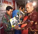  ??  ?? course KREATIF: Guru SMP Al Hikmah Sriyanto (kiri) menerima penghargaa­n dari Sekretaris Dispendik Kota Surabaya Aston Tambunan pada Jumat malam (24/11).