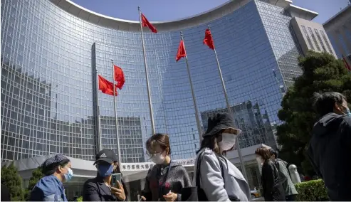  ?? ?? People wearing face masks stand in line for coronaviru­s tests at an office building in the Dongcheng district of Beijing, Tuesday, April 26, 2022.