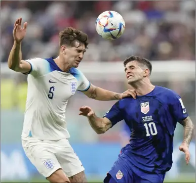  ?? LUCA BRUNO — THE ASSOCIATED PRESS ?? Christian Pulisic of the U.S., right, competes for the ball against England's John Stones during Friday's World Cup match in Qatar.