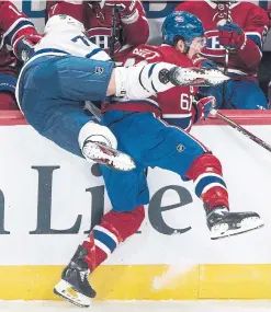  ?? GRAHAM HUGHES THE CANADIAN PRESS ?? Canadiens defenceman Xavier Ouellet checks Maple Leafs forward Kyle Clifford into the Montreal bench on Saturday.