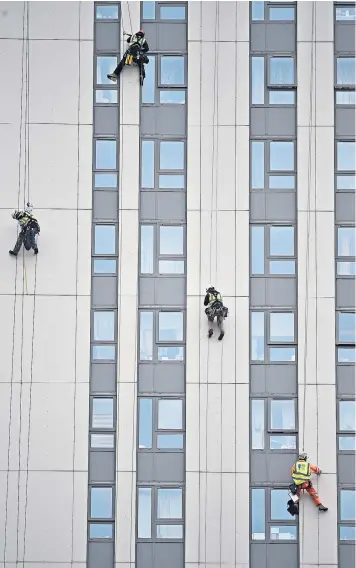  ??  ?? Fire safety specialist­s abseil down the side of Bray Tower, on the Chalcots estate in north London, to check the quality of the cladding