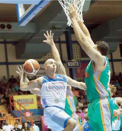  ??  ?? Carlos Arroyo, de los Cariduros de Fajardo, pasa el balón luego de atraer hacia él la defensa de Alex Galindo y de otro canastero de los Caciques de Humacao. Fue el primer juego de Arroyo con Fajardo en 20 años.