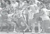  ?? MICHAEL LAUGHLIN/SUN SENTINEL ?? Cardinal Gibbons’ Sidney Porter, No. 8, celebrates his intercepti­on return for a touchdown against American Heritage during the second half Friday night.