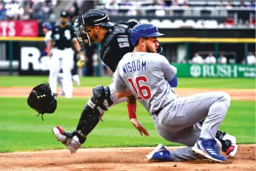  ?? QUINN HARRIS/GETTY IMAGES ?? Sox catcher Yasmani Grandal loses his glove trying to tag out Patrick Wisdom in the first inning Saturday at Guaranteed Rate Field.