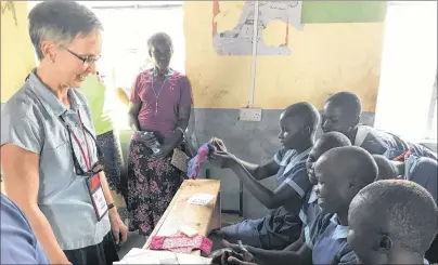  ?? SUBMITTED PHOTO ?? Kathy Mutch works with young Kenyan women learning to use washable feminine hygiene kits. The kits are handmade in P.E.I. by groups of people who like to sew. During Mutch’s recent trip to Kenya, 266 kits were given to girls on Mageta Island and 100...