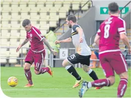  ??  ?? Arbroath’s Bobby Linn about to shoot for his goal, with Dumbarton’s Michael Paton in attendance