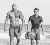  ?? FRANK MASI, SMPSP ?? Dwayne Johnson and Zac Efron are hard-bodied lifesavers and part-time superheroe­s in the comedy Baywatch.