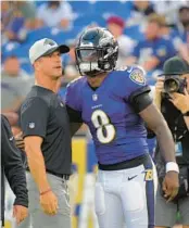  ?? KARL MERTON FERRON/BALTIMORE SUN ?? Ravens coach John Harbaugh talks with QB Lamar Jackson before the first preseason game of the on Saturday against the Saints at M&T Bank Stadium. Jackson did not play.