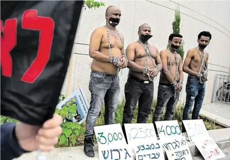  ?? Afričtí migranti včera v Tel Avivu protestova­li proti deportaci, jež jim stále hrozí poté, co Izrael odstoupil od přesídlova­cí dohody s OSN FOTO ČTK/ AP ?? Řetězy spoutaní