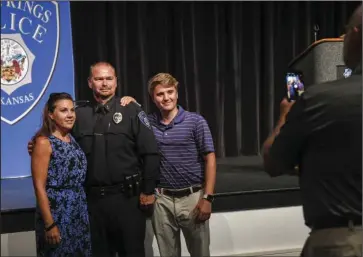  ?? The Sentinel-Record/Grace Brown ?? FAMILY: Newly pinned Hot Springs Police Chief Chris Chapmond, center, has his photo taken with his wife, Elizabeth, and stepson, Nicholas Hinson, following his pinning inside Horner Hall at the Hot Springs Convention Center on Thursday.