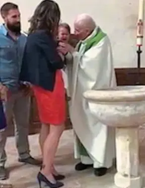  ?? ?? Tears: Fr Jacques Lacroix at the crying toddler’s baptism in Paris