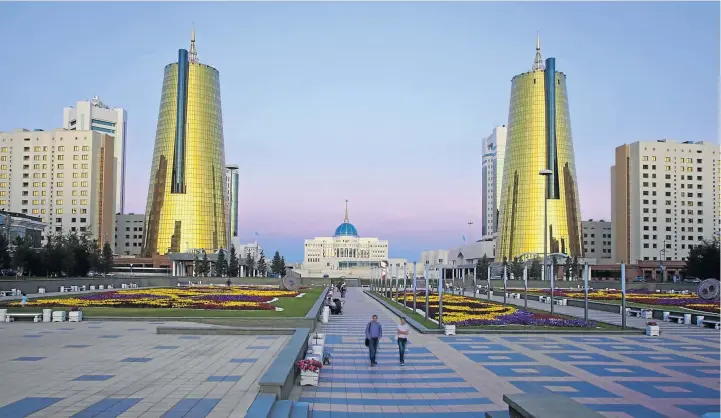  ?? Picture: GREATSTOCK/CORBIS ?? YELLOW-BRICK ROAD: The grandiose Ak Orda Presidenti­al Palace of President Nursultan Nazarbayev in Astana is flanked by the Twin Golden Conical Business Centres in the foreground