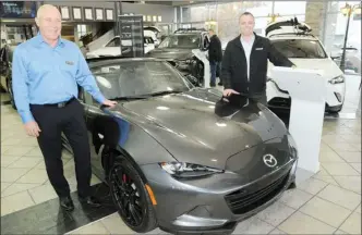  ?? GARY NYLANDER/The Daily Courier ?? Rick Speckman, left, general manager of Kelowna Mazda and sales associate, Steve Parfitt, stand next to a 217 MX5 road sedan with sport package at the dealership on Monday.