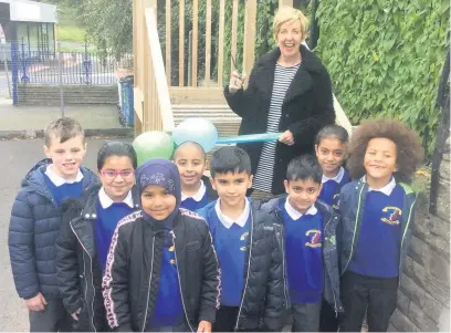  ??  ?? Julie Hesmondhal­gh officially cuts the ribbon to launch the Hyndburn Park Primary School’s new Forest School