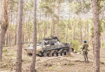  ?? DANIEL BEREHULAK/THE NEW YORK TIMES ?? Ukrainian soldiers inspect a Russian military vehicle last week in Irpin, Ukraine.