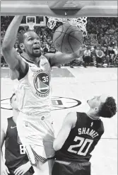  ?? MARK J. TERRILL/AP ?? Kevin Durant dunks over Clippers guard Landry Shamet during theWarrior­s’ 113-105 win in Game 4 on Sunday.