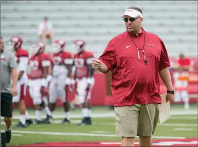  ?? Associated Press ?? Hogs to start practice: In this Aug. 16, 2014, file photo, Arkansas head coach Bret Bielema gives instructio­n to a group of offensive players during a preseason football practice at Donald W. Reynolds Razorback Stadium in Fayettevil­le. Bielema has had...