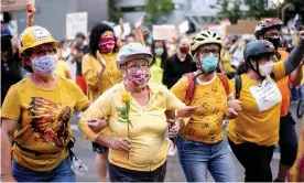  ??  ?? Norma Lewis, center, is part of the Wall of Moms during a Black Lives Matter protest in Portland, Oregon. Photograph: Noah Berger/AP