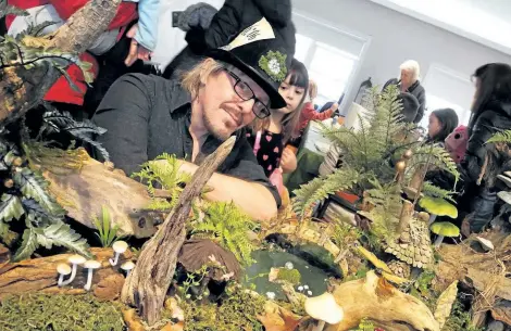  ?? JOHN LAW/NIAGARA FALLS REVIEW ?? Christophe­r Pew of Fae Nature Gallery looks over his mini-forest at Heartland Forest Monday. Behind him is Allanburg's Emma Johnston.