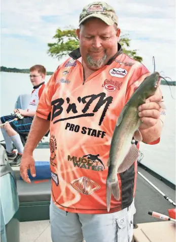  ?? PHOTOS BY GARY GARTH, SPECIAL FOR USA TODAY ?? Billy Blakley (that’s his son Jack in the background) shows off a Reelfoot Lake channel catfish. “Catfishing is just a lot of fun,” he says.