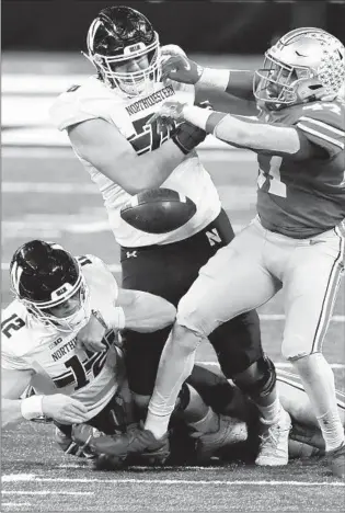  ?? BRIAN CASSELLA/CHICAGO TRIBUNE PHOTOS ?? Northweste­rn quarterbac­k Peyton Ramsey fumbles in the fourth quarter Saturday against Ohio State.