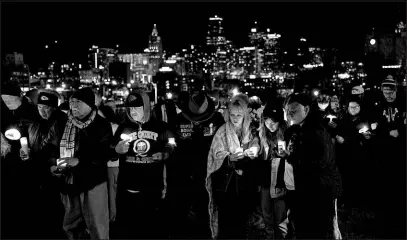  ?? CHARLIE RIEDEL / ASSOCIATED PRESS ?? People attend a candleligh­t vigil Thursday for victims of a shooting at the Kansas City Chiefs Super Bowl parade in Kansas City, Mo. More than 20 people were injured and one woman killed in the shooting near the end of Wednesday’s rally held at nearby Union Station.