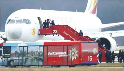  ??  ?? Police officers help a passenger disembark hijacked Ethiopian Airlines flight ET 702 at Cointrin airport in Geneva yesterday.