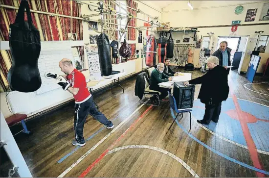  ?? LINDSEY PARNABY / AFP ?? Una dona introdueix la seva papereta en una urna establerta en el club de boxa d’East Hull, a Kingston-Upon-Hull (nord d’Anglaterra)
