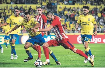  ??  ?? BELGA. Yannick Ferreira Carrasco, de Atlético de Madrid, supera la marca de David Simon, de Las Palmas. Los madridista­s golearon 5-1 en este encuentro.