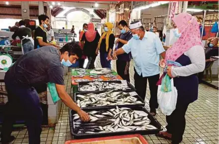  ?? BERNAMA PIC ?? People buying essentials at a market in Alor Star, which is under the Enhanced Movement Control Order, on Monday. Local authoritie­s have the power to revoke business licences of premises that flout Covid-19 standard operating procedures.