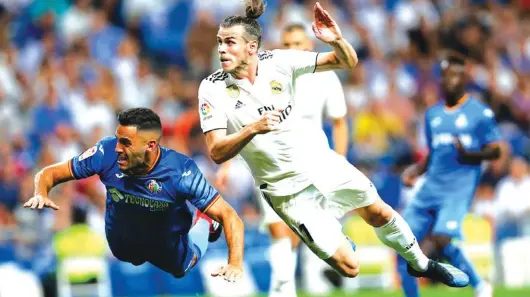 ??  ?? Real Madrid’s Gareth Bale, right, tries to score next to Getafe’s Bruno Cabrera Photo: AP