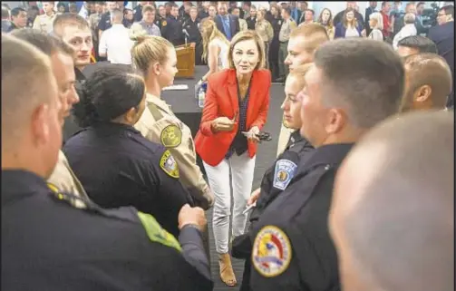  ??  ?? Iowa Gov. Kim Reynolds, a Republican, hands pens to law enforcemen­t officers after signing the Back the Blue bill Thursday. The bill expands qualified immunity for officers and enhances penalties for protesters.