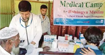  ??  ?? DOKTOR memberikan rawatan kepada warga emas etnik Rohingya di klinik yang disediakan NGO di kem pelarian di Bangladesh.