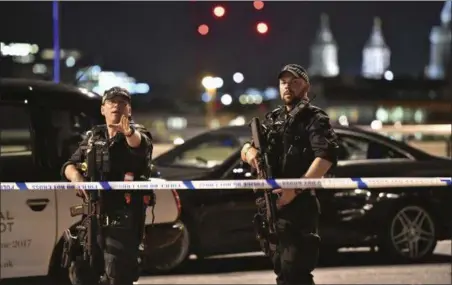  ?? DOMINIC LIPINSKI — PA VIA AP ?? Armed Police officers stand guard on London Bridge in central London, Saturday. British police said they were dealing with “incidents” on London Bridge and nearby Borough Market in the heart of the British capital Saturday, as witnesses reported a...