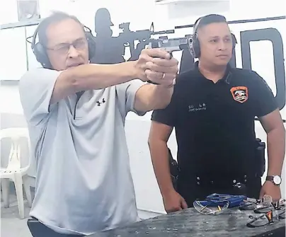  ?? PHOTOGRAPH BY PAT SANTOS FOR THE DAILY TRIBUNE ?? JUDGE Jimmy Santiago (left) sent a lot of criminals scampering (or to meet their Maker) with his true aim. At the Manila Police District’s newly renovated SWAT firing range, Santiago is assisted by present SWAT chief P/Capt. Leo So in hitting the Alpha.