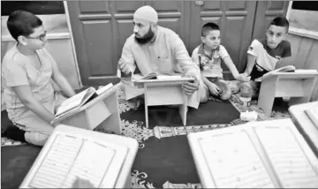  ??  ?? A Palestinia­n Sheikh teaches children to read the Quran inside al-Aqsa Mosque. — Reuters photo
