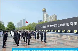  ?? —AFP ?? WUHAN: People bow during a three-minute national memorial to commemorat­e those who died in the COVID-19 coronaviru­s outbreak yesterday.